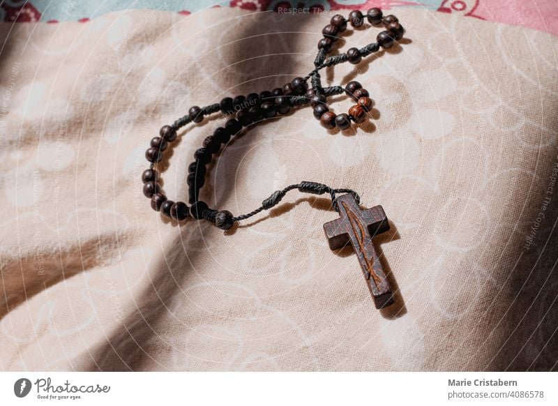 Hölzernes Rosenkranzkreuz als Symbol für das Christentum und die Fastenzeit religiöse Feier geistig Konzept christliche Rosenkranzperlen Liebe Anbetung