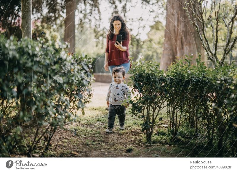 Mutter fotografiert Kind beim Spielen im Park Fotografieren Mutter mit Kind Kaukasier 1-3 Jahre Spaß haben Leben Eltern Liebe Zusammensein Freude Glück
