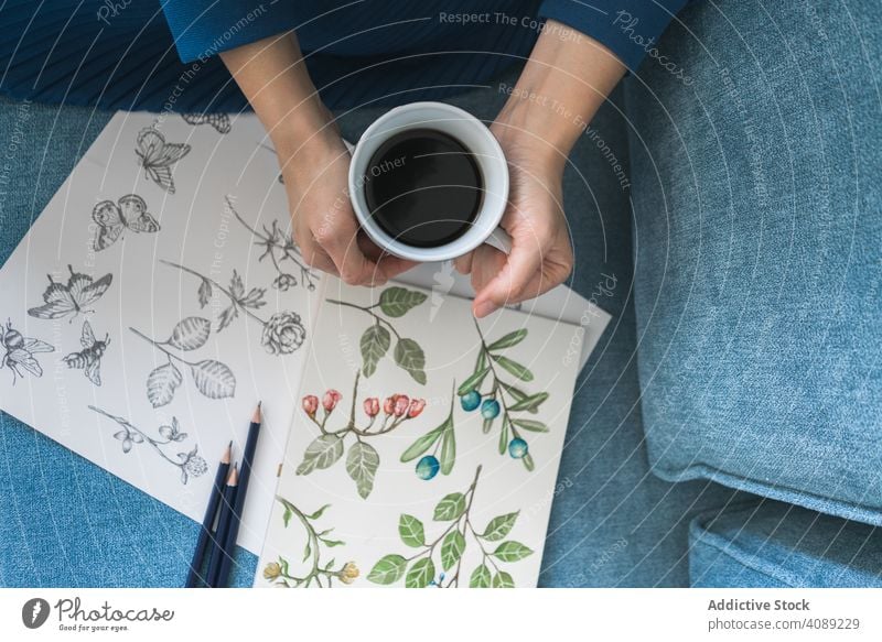 Junge anonyme Frau mit Kaffee suchen Album mit Bildern Blick Anstreicher Arbeit Kunst Tasse Künstler Arbeitsplatz Kreativität Handwerk brünett Freizeit Design