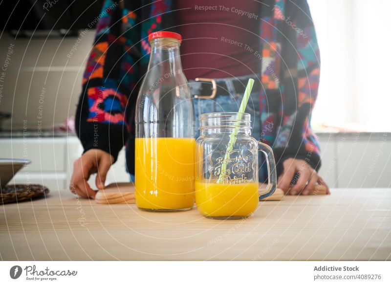Orangensaft in Küchenarbeitsplatte Saft Zitrusfrüchte Glas Frau orange Strohhalme Tisch frisch trinken Gesundheit Getränk Erfrischung süß reif Scheibe