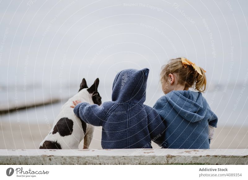 Kinder umarmen Hund am Strand Freundschaft Liebe umarmend Haustier MEER Sitzen gehorsam Baby französische Bulldogge lässig Lifestyle Freizeit ruhen