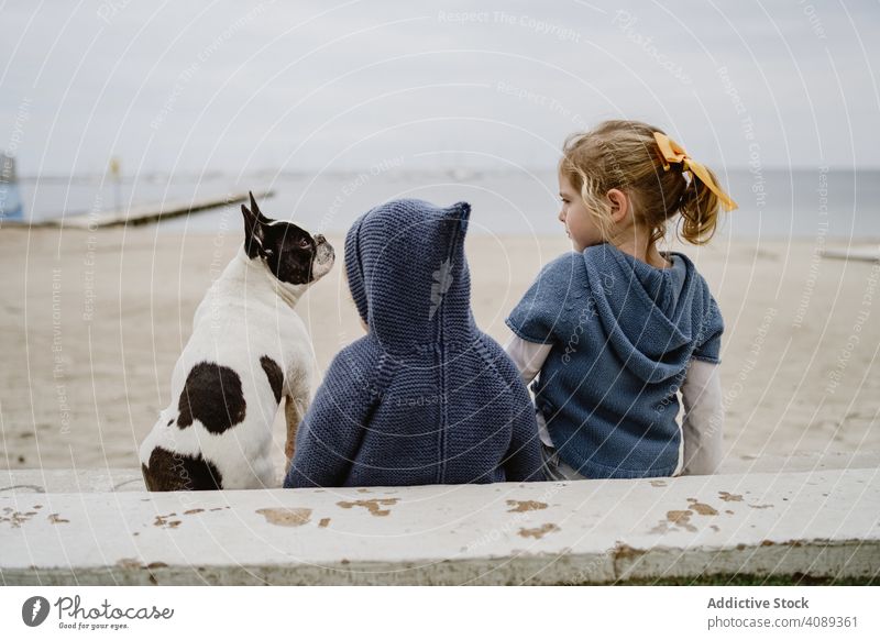 Kinder umarmen Hund am Strand Freundschaft Liebe umarmend Haustier MEER Sitzen gehorsam Baby französische Bulldogge lässig Lifestyle Freizeit ruhen