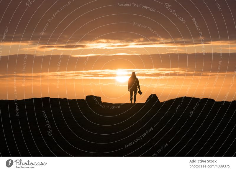 Frau mit Buch stehend bei Sonnenuntergang Silhouette Stehen Menschen Lifestyle Natur Sonnenaufgang Wales eine Freiheit menschlich Fröhlichkeit Konzept Glück