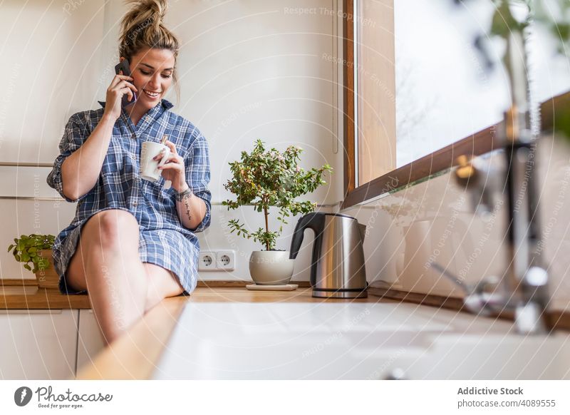 Frau zu Hause Menschen Funktelefon Küche Lächeln Glück Technik & Technologie Gespräch Lifestyle Mahlzeit Mitteilung blond Tippen lesen im Inneren klug Internet