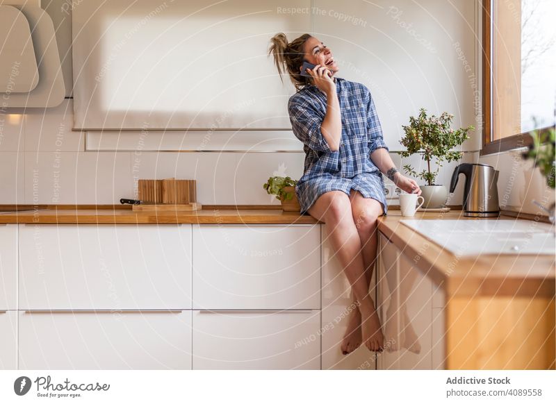 Frau zu Hause Menschen Funktelefon Küche Lächeln Glück Technik & Technologie Gespräch Lifestyle Mahlzeit Mitteilung blond Tippen lesen im Inneren klug Internet