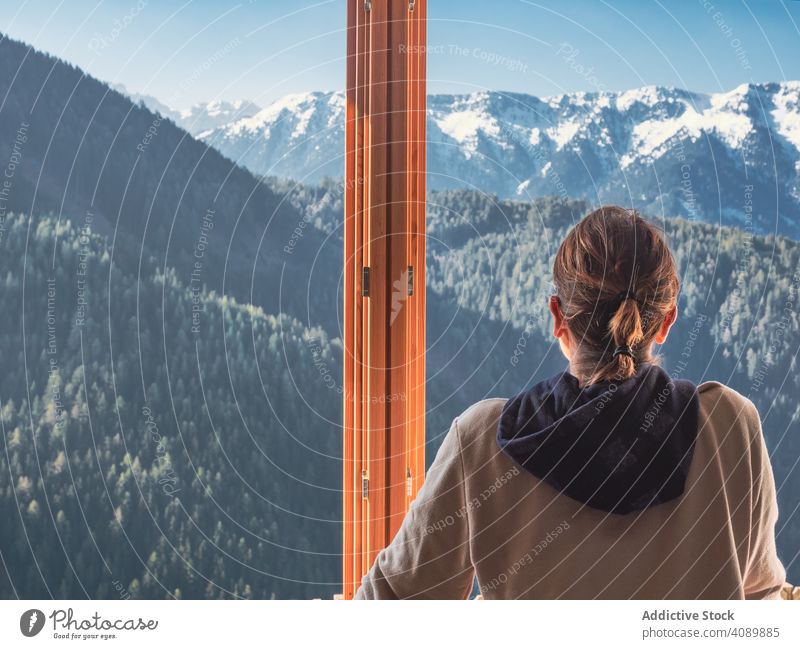 Anonyme Frau schaut aus dem Fenster auf die Berge bewundernd Lehnen Fensterbrett heimwärts sonnig tagsüber sorgenfrei Natur Landschaft Lifestyle Freizeit ruhen