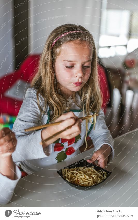 Mädchen isst veganes Essen zu Hause Kinder Veganer Lebensmittel Nudeln Küche heimwärts Sitzen Tisch Zusammensein Essstäbchen Geschwister Schnitzel Gemüse