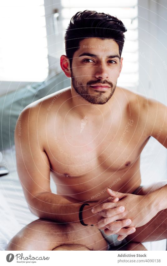 Junge sexy nachdenklich Mann sitzt auf dem Bett Unterwäsche besinnlich Bücher jung männlich gutaussehend gelungen cool nackt heiß brutal Stück Macho muskulös