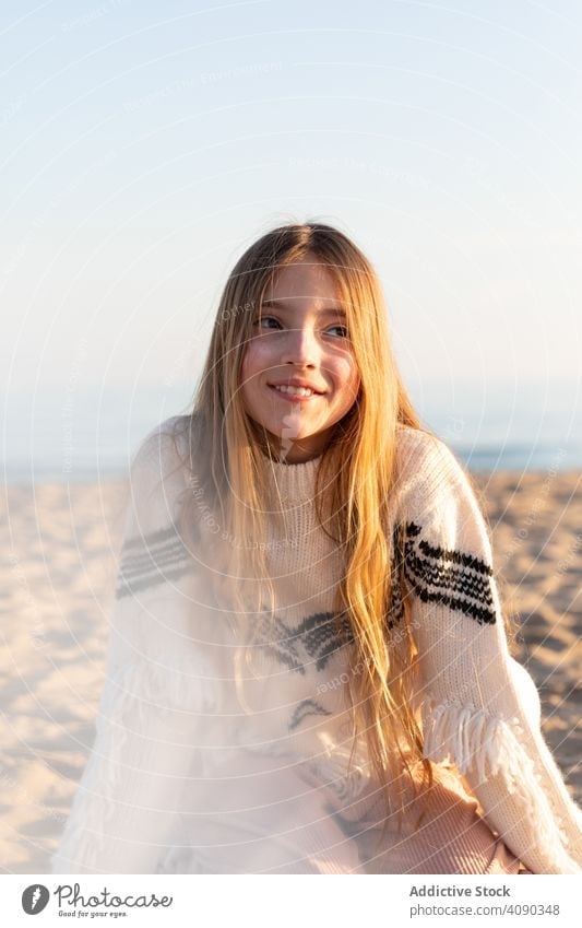 Teenager-Mädchen am Strand schaut weg durchblickend Lächeln neugierig Spielfigur durchsichtig Pullover ruhen sich[Akk] entspannen Lifestyle Freizeit Farbe
