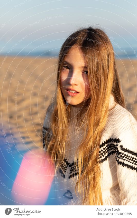 Teenager-Mädchen schaut in die Kamera am Strand durchblickend Lächeln neugierig Spielfigur durchsichtig Pullover ruhen sich[Akk] entspannen Lifestyle Freizeit