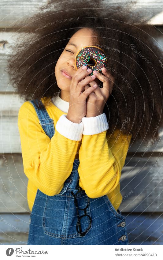 Junges Mädchen isst Donuts mit Vergnügen Essen Lebensmittel jung geschmackvoll Menschen hübsch Person lustig Zucker Kuchen Bäckerei hungrig ungesund Lifestyle