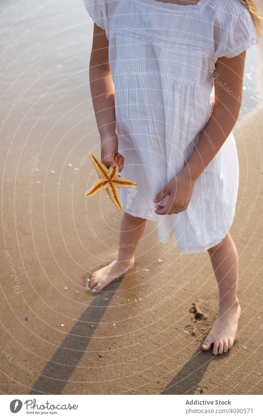 Mädchen hält Seestern am Strand Beteiligung MEER Sommer Urlaub Meer Wasser reisen schön Natur Feiertag Kind Glück Person Hand Küste Menschen Tourismus Sand Tier