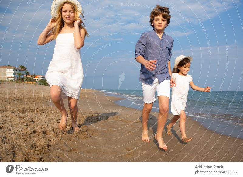 Kinder laufen am Meeresufer entlang rennen Strand Sommer Urlaub MEER Lifestyle Glück Zusammensein Fröhlichkeit Wasser Sand Menschen Freude Feiertag schön