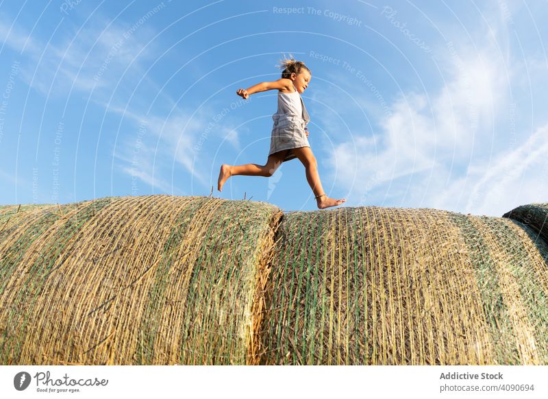 Barfuß Mädchen läuft auf Heuhaufen rennen Bauernhof Himmel Wolken sonnig tagsüber Natur Lifestyle Freizeit Teenager Kind getrocknet Gras Stroh Brötchen