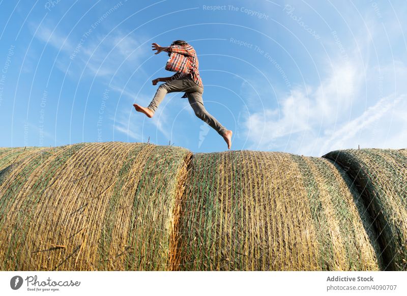Barfuß Junge läuft auf Heuhaufen rennen Bauernhof Himmel Wolken sonnig tagsüber Natur Lifestyle Freizeit Teenager Kind getrocknet Gras Stroh Brötchen Landschaft