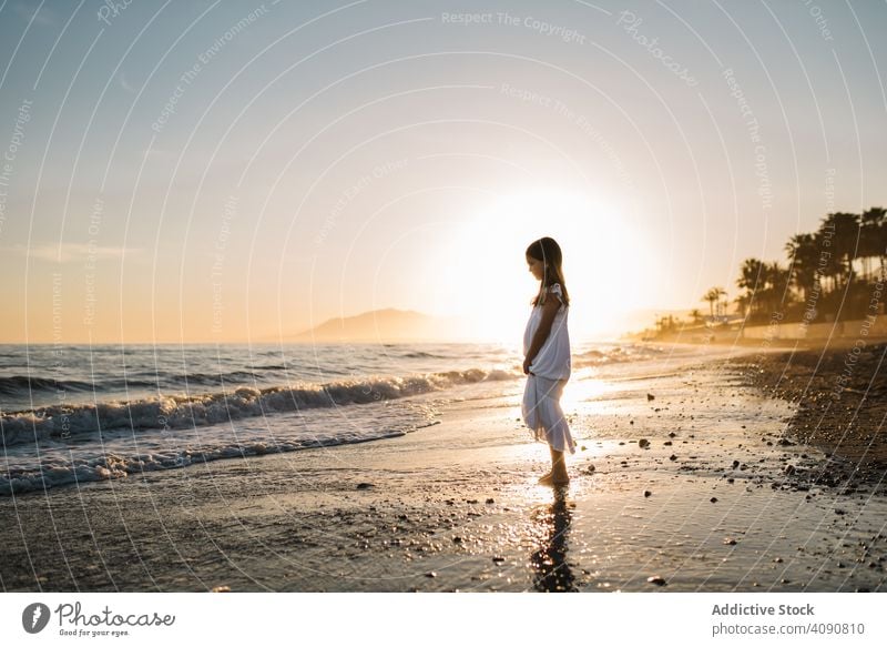 Adorable Mädchen zu Fuß am Meer bei Sonnenuntergang Seeküste laufen bezaubernd Meeresufer Sonnenschein Strand Sommer Wasser MEER sonnig Kind Kindheit Glück