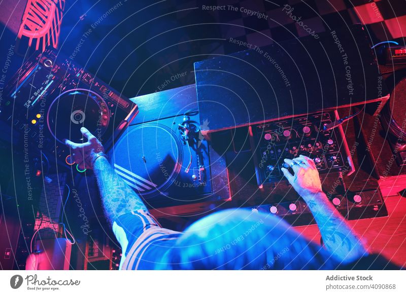 Von oben ein anonymer DJ-Mann, der in einem Club mit Lichtern spielt Nachtclub Hand Entertainment Aufzeichnen spielen Gerät Plattenteller Party Scheibe