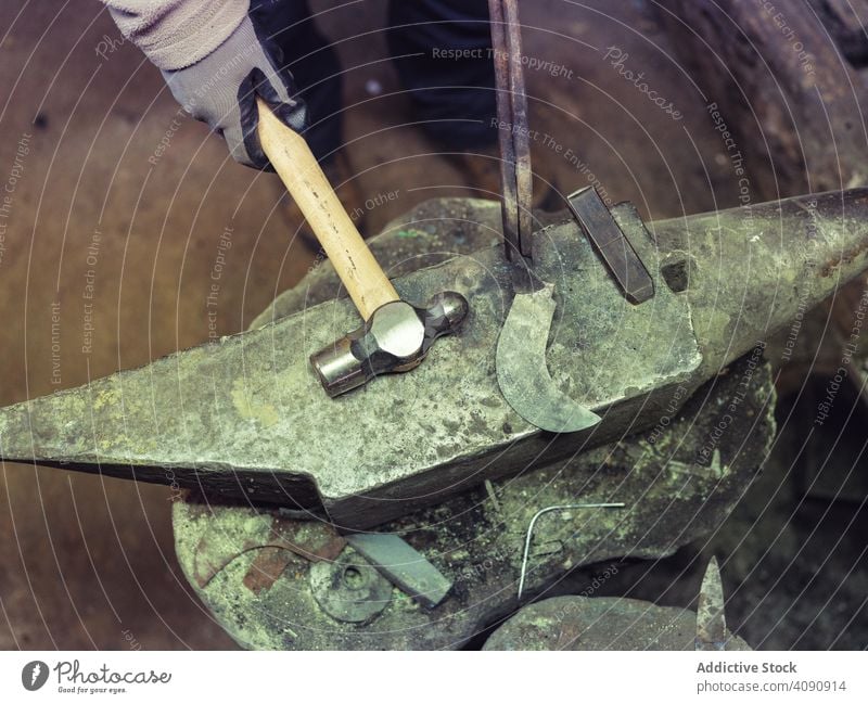 Schmied hält Metall auf Amboss in traditioneller Schmiede Hufschmied schmieden Hammer Gerät Werkzeuge Werkstatt Handwerk alt Fähigkeit schwer Metallbearbeitung