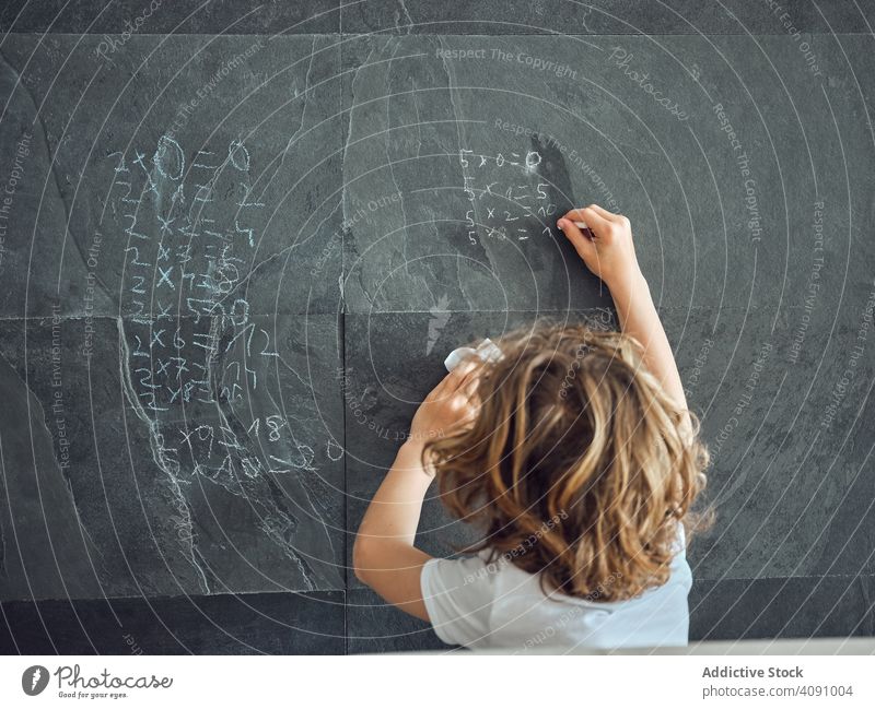 Junge schreibt Multiplikationstabelle an der Wand schreibend Bildung Kind lernen Schule studierend Wissen Lektion Mathematik primär wenig Kreide schwarz grau