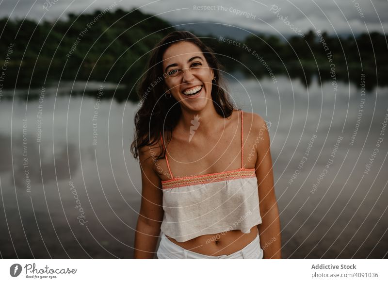 Porträt der heiteren Frau in der Natur in die Kamera schauen Lächeln See jung Wasser Windstille ruhig Glück Freude Aktivität Dame Lifestyle Freizeit Spaß lässig