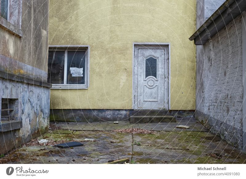 Innenhof eines verlassenen Hauses Architektur Gebäude dreckig verfallen alt trist gelb Menschenleer Fassade Farbfoto Wand Vergänglichkeit Tür Eingang Leerstand
