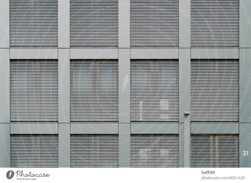 Moderne Aussenfassade mit geschlossenen Jalousien Lamelle Lamellenjalousie Fenster Kontrast Moderne Architektur Fassade Rollladen Rollo Mauer Schatten trist