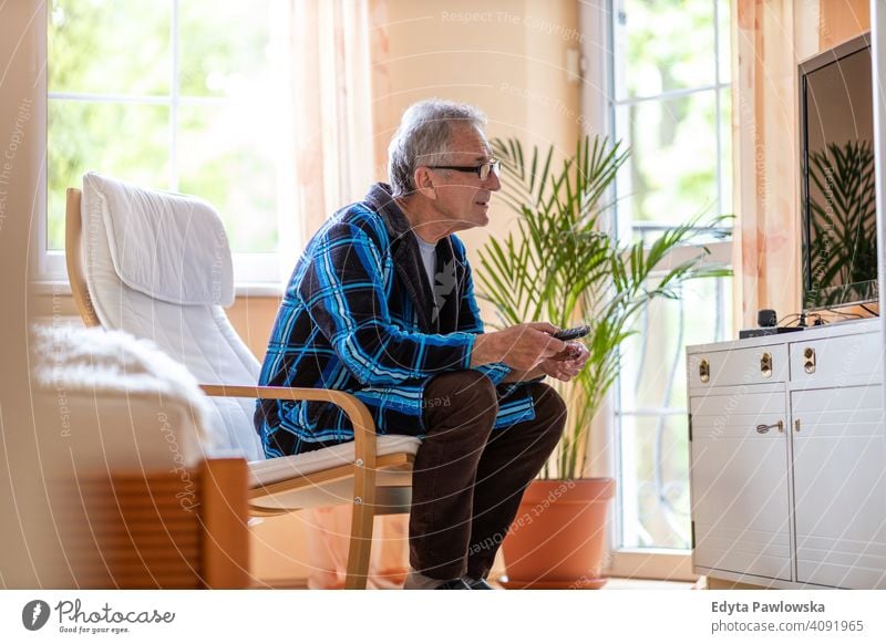Senior Mann mit TV-Fernbedienung älter Großvater alt Rentnerin in den Ruhestand getreten gealtert reif heimwärts Haus männlich Menschen Lifestyle