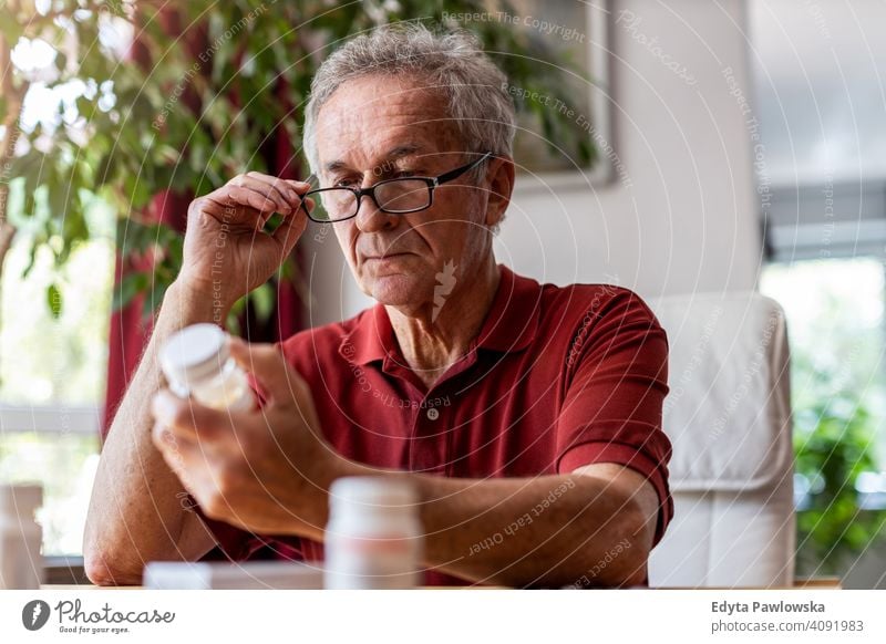 Älterer Mann nimmt verschreibungspflichtige Medikamente zu Hause ein Senior älter Großvater alt Rentnerin in den Ruhestand getreten gealtert reif heimwärts
