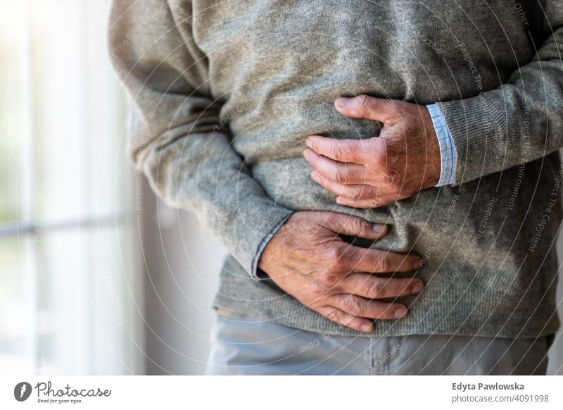 Älterer Mann mit Magenschmerzen Bauchschmerzen Unterleib Schmerzen Unterleibsschmerzen Reflux Lebensmittelvergiftung Gastroösophageale Refluxkrankheit
