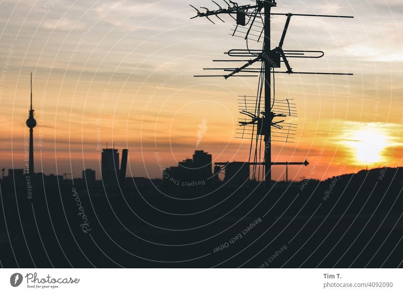auf einem Dach bei Sonnenuntergang in Berlin . Im Bild sind eine Antenne und der Berliner Fernsehturm tv tower Himmel Wahrzeichen Hauptstadt Sehenswürdigkeit