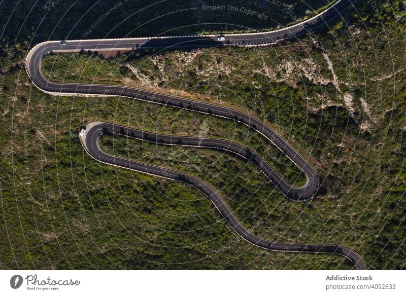 Kurvenreiche Straße durch Wüstenlandschaft biegend wüst Landschaft Drohnenansicht leer Antenne geschlängelt abgelegen grün Teneriffa Spanien sonnig Licht reisen