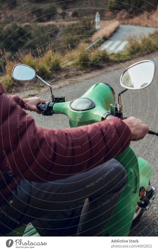 Mann in warmer Jacke sitzt auf Roller und hält Rad Tretroller Fahrrad Aktivität Straße Freizeit Abenteuer Motorrad reisen genießend Transport Verkehr jung