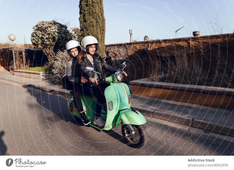 Junge Menschen auf Motorrädern in der Stadt Schutzhelm Freundschaft Tretroller Fahrrad Aktivität Straße Freizeit Abenteuer Motorrad reisen genießend Transport