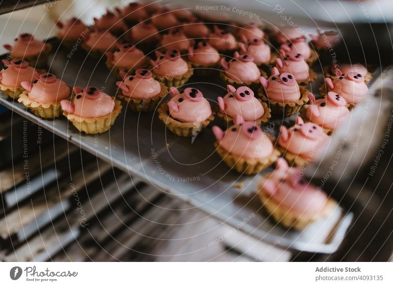 Tablett mit schweineförmigen Desserts in der Bäckerei Gebäck Schwein Ablage Form Symbol klein rosa Kuchen Ohr Schnauze Lebensmittel süß frisch backen