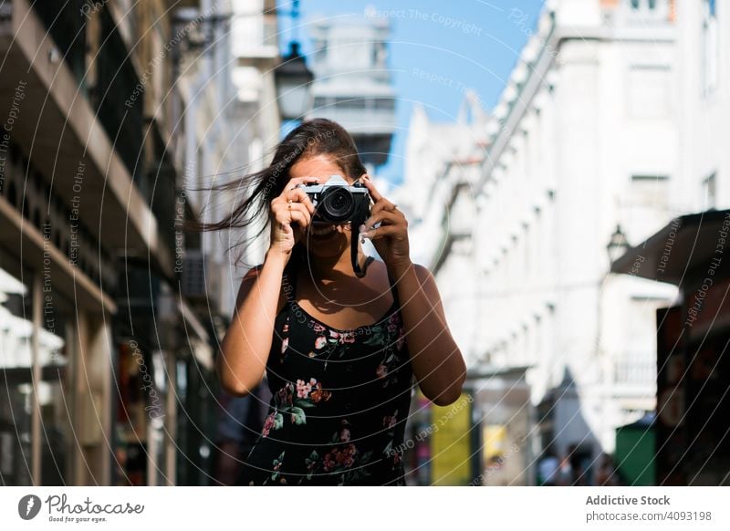 Lässige Frau, die ein Foto mit der Kamera macht, während sie auf der Straße steht fotografierend Stadt reisen lässig Fotokamera selbstbewusst Bild malerisch