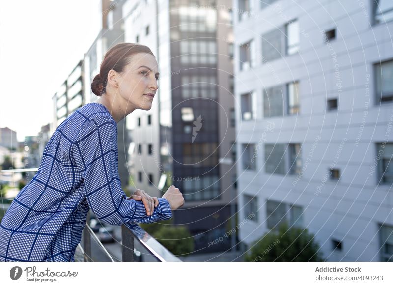 Lächelnde Geschäftsfrau auf Balkon stehend Büro Großstadt sonnig tagsüber Pause ruhen jung Frau Business professionell sich[Akk] entspannen Reling heiter Freude