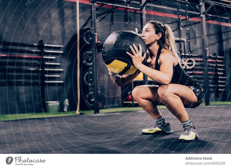 Muskulöse Frau trainiert mit Ball im Fitnessstudio Übung Fitball Training Fitness-Studio sportlich muskulös Sportbekleidung passen Gesundheit Körper aktiv