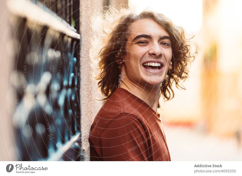 Positiver gut aussehender Mann lächelt auf der Straße gutaussehend Lächeln positiv Inhalt Menschliches Gesicht selbstbewusst lange Haare Glück modern heiter