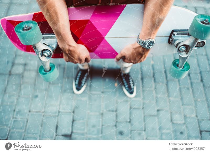 Sportlicher Mann mit buntem Longboard auf der Straße stehend hell farbenfroh modern urban führen Großstadt Halt sportlich jung Erwachsener passen stark extrem