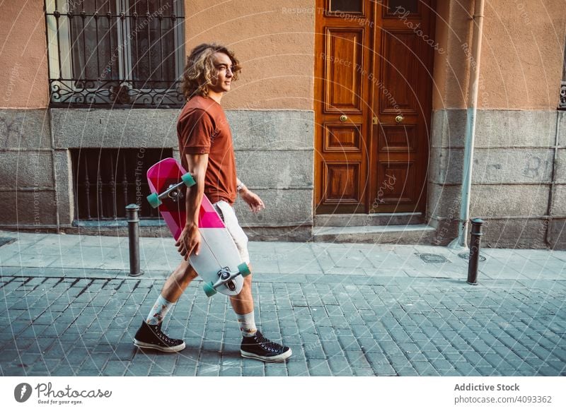 Mann mit Longboard auf der Straße modern urban führen Großstadt stehen Halt sportlich jung Erwachsener passen stark extrem Arme Sport Holzplatte Übung Lifestyle