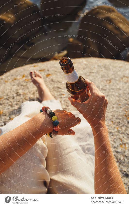 Frau entspannt sich und trinkt Bier am Strand Küste Seeküste trinken räkeln Erfrischung Kälte Sonnenlicht genießen Einsamkeit Flasche reisen Alkohol Feiertage