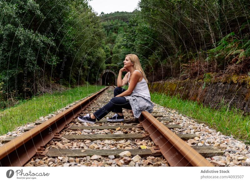 Frau sitzt auf der Eisenbahn, obwohl der grüne Teil der Straße extrem Wald reisen Reise Hain Verkehr Passagier Ausflug klug Tourismus Stahl Natur aktiv Tourist