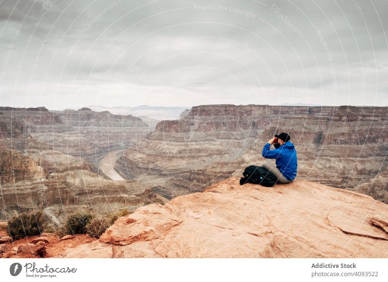 Mann entspannt sich auf einer Klippe und bewundert die malerische Aussicht Schlucht ruhen Felsen sich[Akk] entspannen bewundern Ansicht ruhig Rucksack Jacke USA