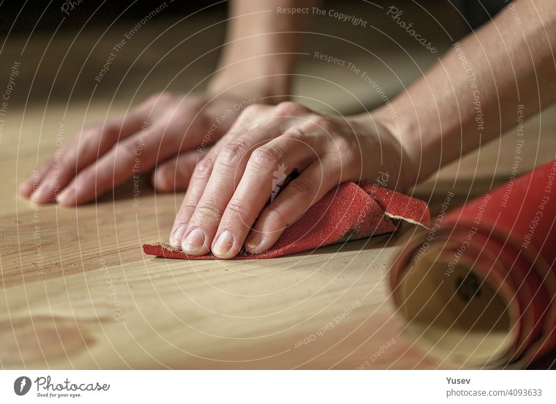 Anmutige weibliche Hände halten Sandpapier. Reiben Holzboden, Haus Arbeit, Wohnung Renovierung. Nahaufnahme. zierlich Frau Kaukasier Beteiligung Schleifpapier