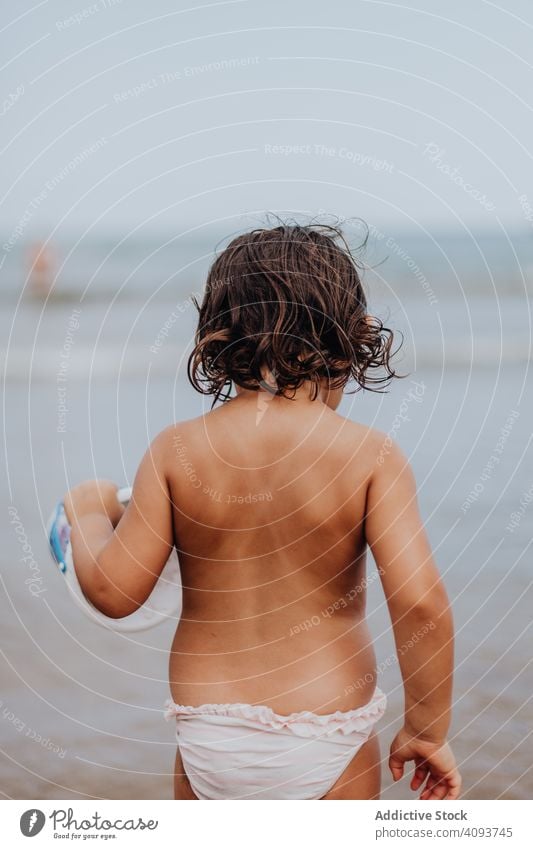 Kleines Mädchen trägt Spielzeugschüssel zum Wasser schreit spielen tragen Strand Sommer sandig Urlaub Kind Feiertag Spaß MEER Spielen Mund Meer Ausdruck