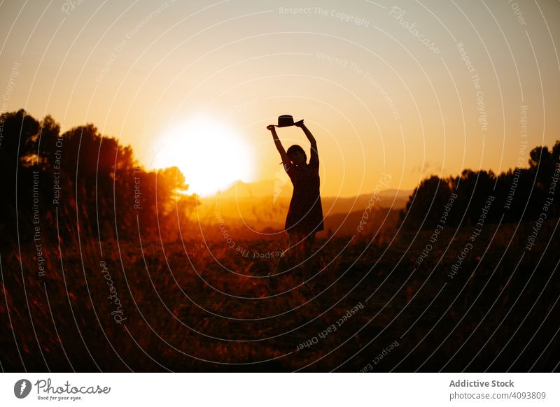 Anonyme Frau tanzt bei Sonnenuntergang Tanzen Feld Natur Abend Himmel Silhouette hell Freiheit Lifestyle ruhen sich[Akk] entspannen Freude Abenddämmerung