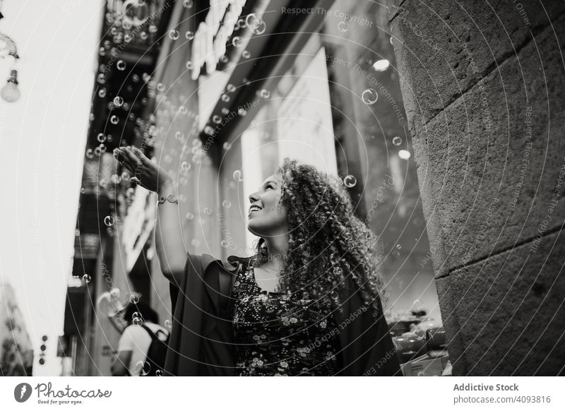 Glückliche Frau fängt Seifenblasen auf der Straße Schaumblase fangen Großstadt Lächeln Spaß Barcelona Spanien spielerisch Freude erfreut optimistisch heiter