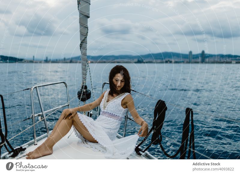 Barfüßige Braut, die auf dem Bug einer Yacht ruht Frau Jacht Junggesellenabschied Party MEER elegant engagiert Feier Veranstaltung Abend Kleid Gefäße Segelboot