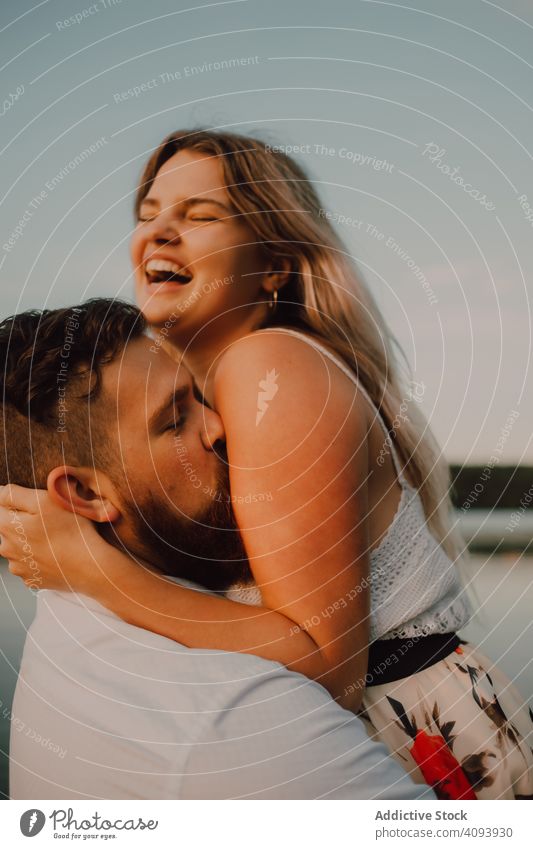 Liebender Mann trägt glückliche Frau auf Händen ans Ufer Paar See Glück Umarmung Tragen auf Händen Zuneigung Romantik Partnerschaft Natur Sommer sanft