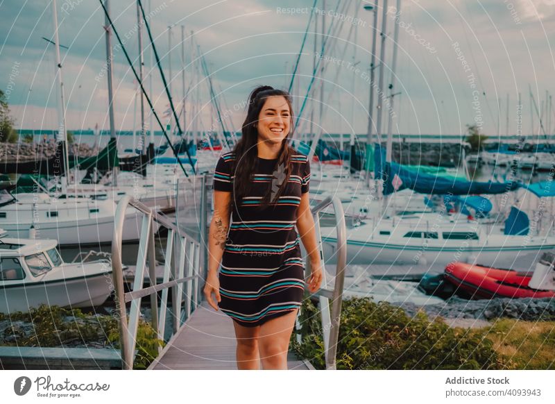 Lächelnde Frau geht entlang eines belebten städtischen Piers Spaziergang Kai hafen Jacht genießen Boot MEER Natur Glück Sommer jung Freizeit Seeküste Jachthafen